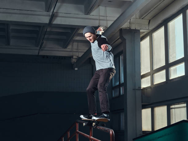 istock Young skateboarder performing a trick on mini ramp at skate park indoor. 1171132149