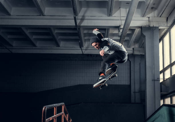 istock Young skateboarder performing a trick on mini ramp at skate park indoor. 1171132163