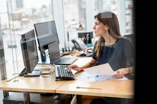 istock Serious businesswoman working at her office with documents and technology 1171132250
