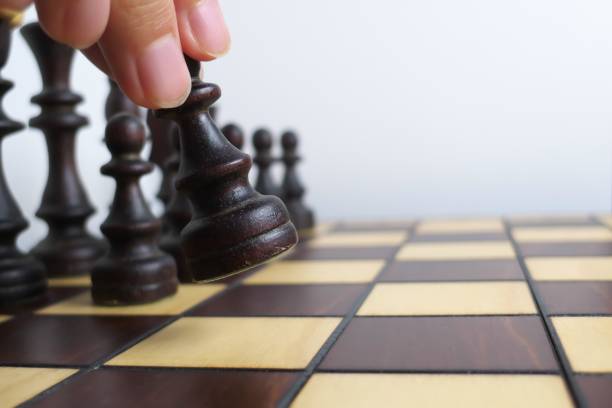 istock Hand and wooden chessboard, isolated on white background 1171133048