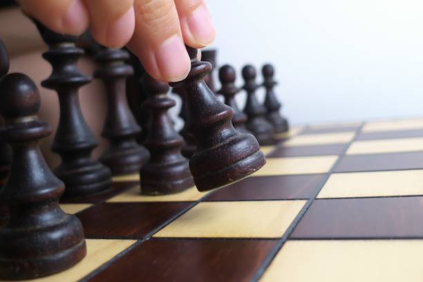 istock Hand and wooden chessboard, isolated on white background 1171133116