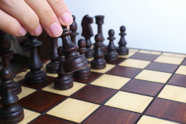 istock Hand and wooden chessboard, isolated on white background 1171133150