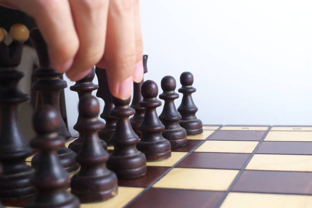 istock Hand and wooden chessboard, isolated on white background 1171133197