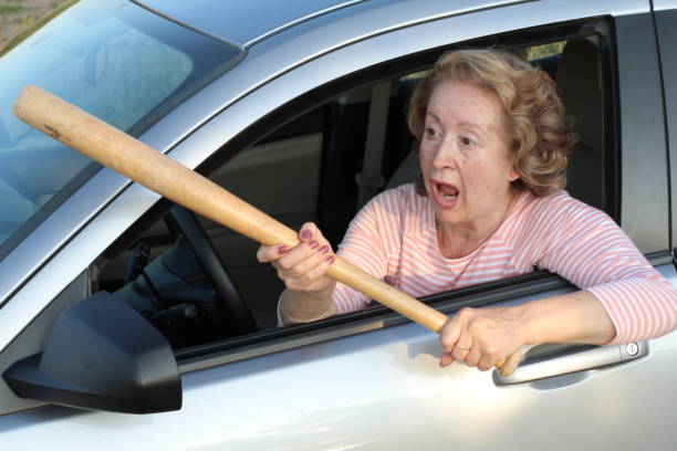 istock Angry mature female driver holding baseball bat 1171134532