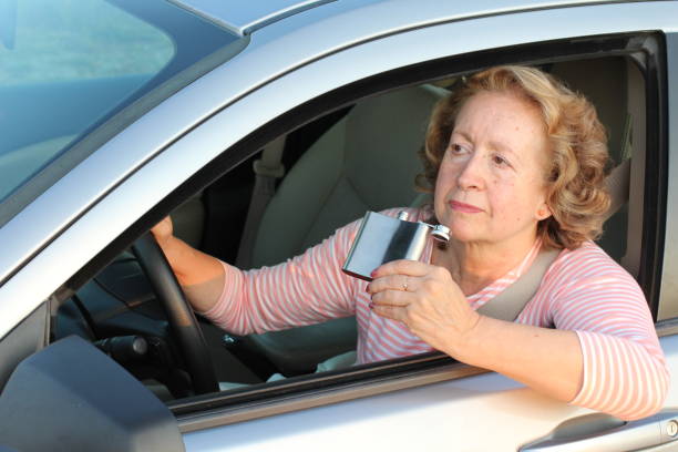 istock Dangerous mature woman drinking and driving 1171138112