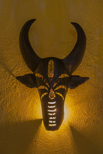A wrought iron wall lamp representing a zebu head