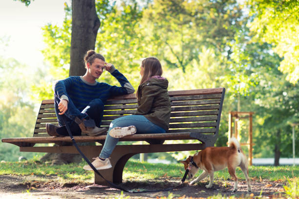 istock Young couple meets on the park bench with dog 1171144704