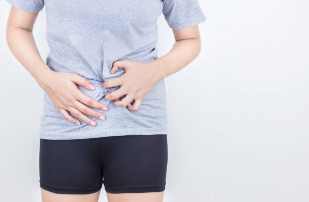 istock Young woman feeling unwell with a stomach ache on white background. 1171145844