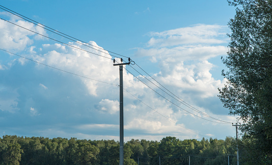 old high-voltage tower against the blue sky in the countryside