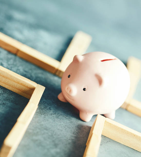 istock Little pink piggy bank navigating a maze 1171149683