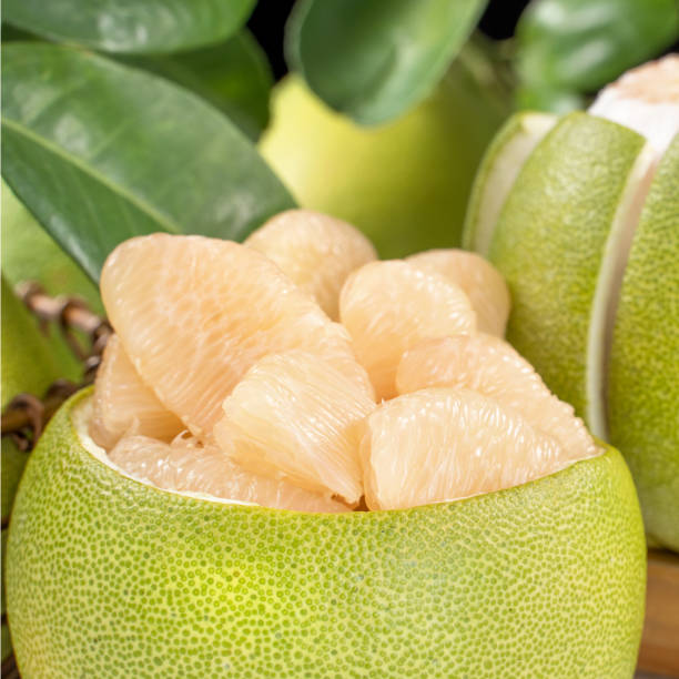 istock Fresh peeled pomelo, grapefruit, shaddock with green leaf on bright wooden plank table. Seasonal fruit near mid-autumn festival. 1171149850