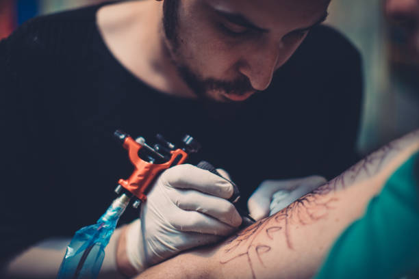 istock Artist tattooing young man in studio 1171149999