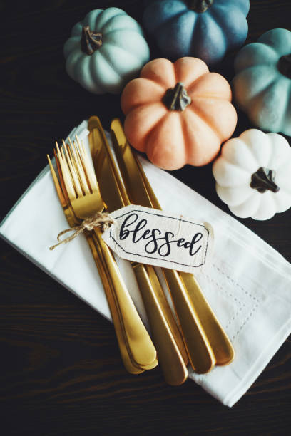 istock Thanksgiving Table Setting Background with Pumpkins and Gold Cutlery 1171152012