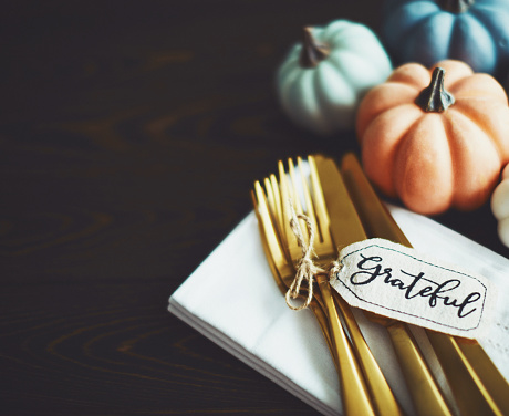 Thanksgiving Table Setting Background with Pumpkins and Gold Cutlery