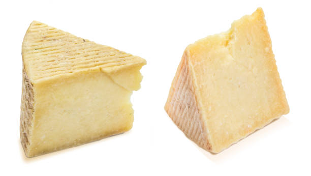 istock Cured sheep cheese (manchego type). Two wedges and portions. Isolated on white background. 1171153256