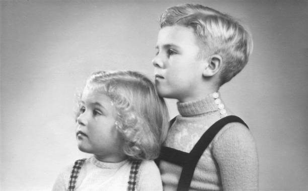 retrato del dúo de principios de la década de 1950 de un niño y una niña con el pelo rubio y rizos mirando hacia los lados. - dutch culture fotos fotografías e imágenes de stock