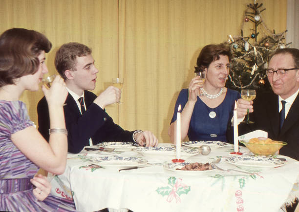Vintage 1950´s image: family enjoying the Christmas holidays with a dinner. Vintage 1950´s image: family enjoying the Christmas holidays with a dinner. family christmas party stock pictures, royalty-free photos & images