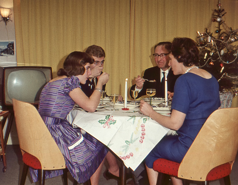 Vintage 1950´s image: family enjoying the Christmas holidays with a dinner.