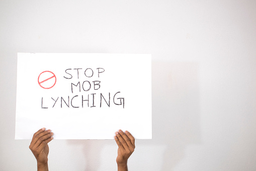 Hands with Placard showing of Stop Mob Lynching on isolated background