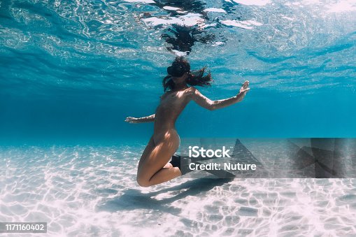 istock Woman free diver with fins posing over sandy sea. Freediving underwater in blue ocean 1171160402