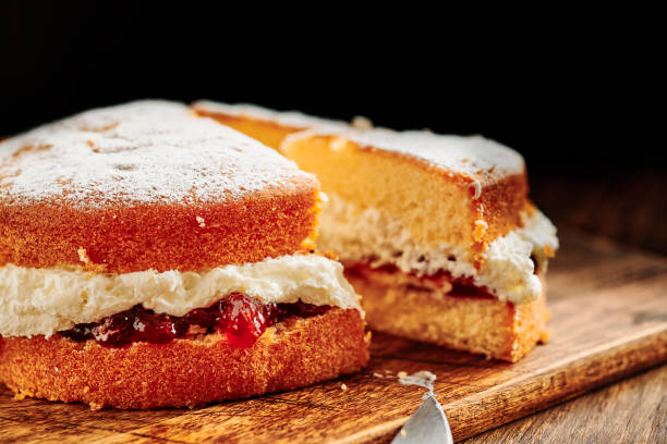 istock Sliced Victoria sponge cake on a rustic chopping board. 1171160826