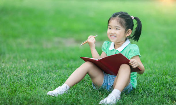 istock Cute little girl learning on the lawn 1171162188