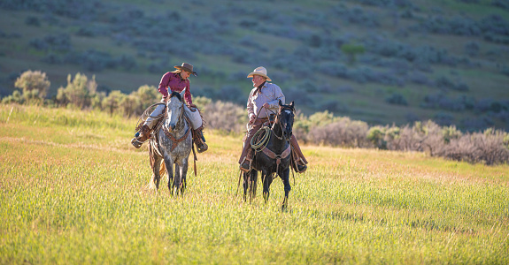 Senior cowboy and cowgirl horseback riding