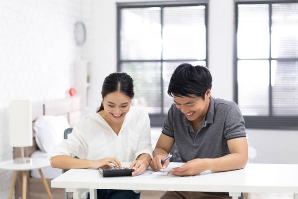 カップルは経費と手形を計算している。 - 職場 人間関係 悩み ストックフォトと画像