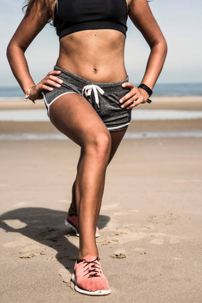 istock young woman doing stretching on the sunny beach 1171171121