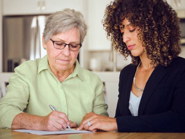 istock Senior Woman Signing Documents in Her Home 1171173386
