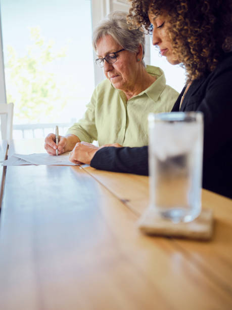 istock Senior Woman Signing Documents in Her Home 1171173415