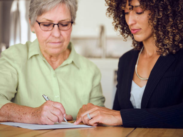 istock Senior Woman Signing Documents in Her Home 1171173417