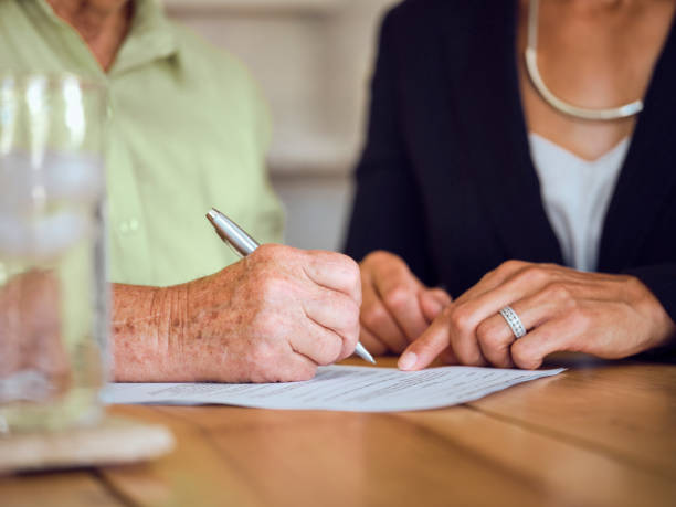 istock Senior Woman Signing Documents in Her Home 1171173422