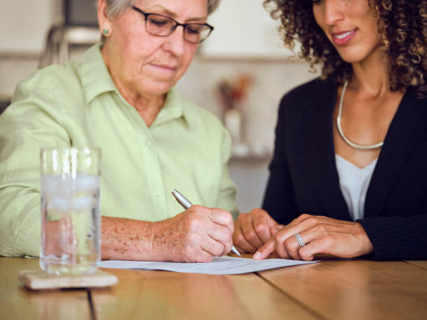 istock Senior Woman Signing Documents in Her Home 1171173625
