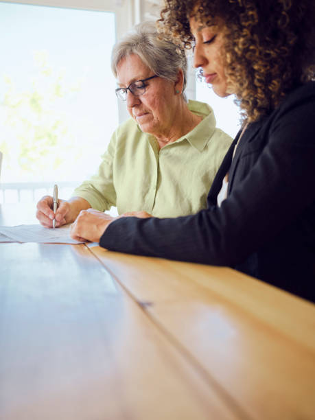 istock Senior Woman Signing Documents in Her Home 1171173626