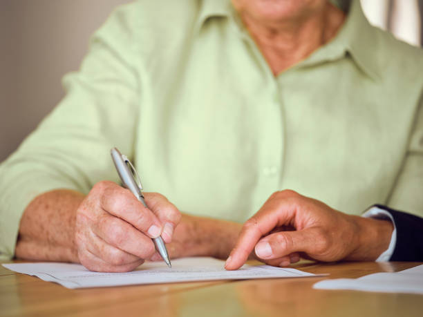 istock Senior Woman Signing Documents in Her Home 1171173657