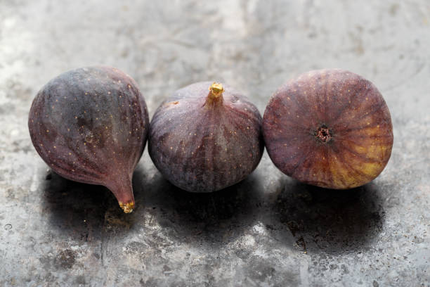 istock whole ripe fresh three figs on a black table. close-up. 1171174317