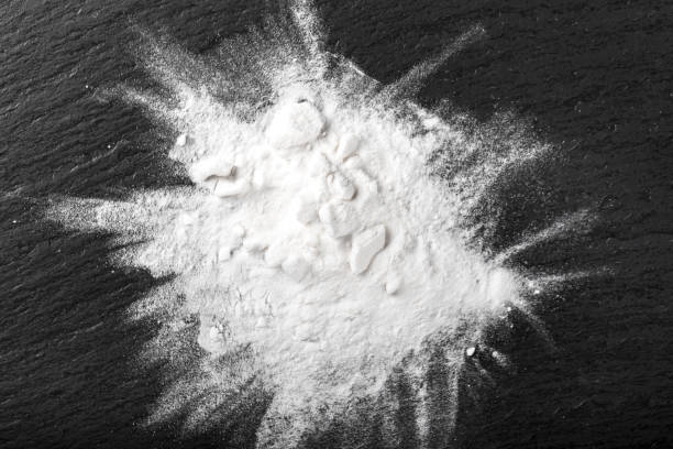 istock white drug powder scattered on a black table. 1171174688