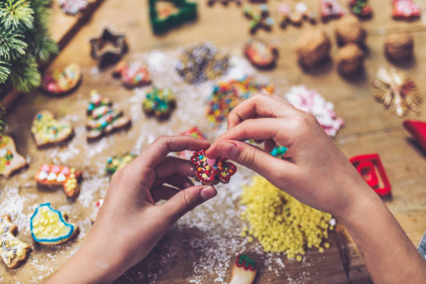 istock female hands decorating christmas cookie at wooden table 1171176005
