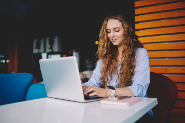 istock Happy female student chatting with friend via communicate application using free wireless internet on laptop device, positive successful woman typing text message on netbook sitting at cafeteria 1171176205