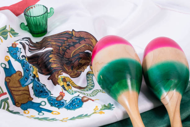 маракас и стакан текилы с мексиканским флагом в качестве фона. - tequila shot стоковые фото и изображения