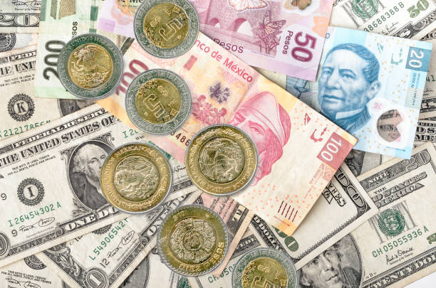 Dollar and Mexican Pesos Mexican Peso Coins over assorted Dollars and Mexican Peso bills cash pile. mexican currency stock pictures, royalty-free photos & images