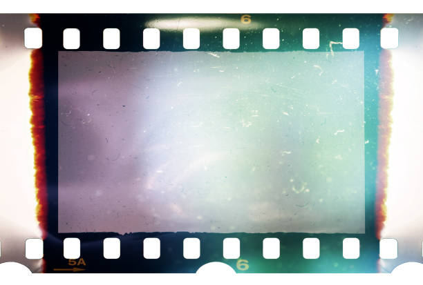 Real and original 35mm or 135 film material or photo frame on white background, 35mm filmstrip with empty window or cell with dust, scratches and cool light effect stock photo