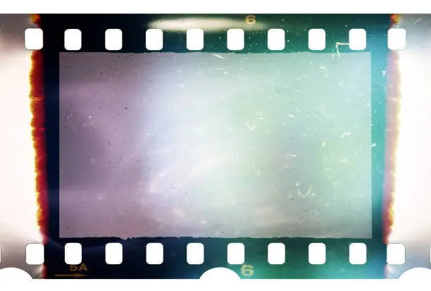 Photo of Real and original 35mm or 135 film material or photo frame on white background, 35mm filmstrip with empty window or cell with dust, scratches and cool light effect