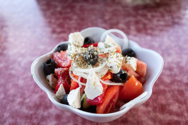 istock Greek salad in a white bowl. Salad on a red background. 1171178708