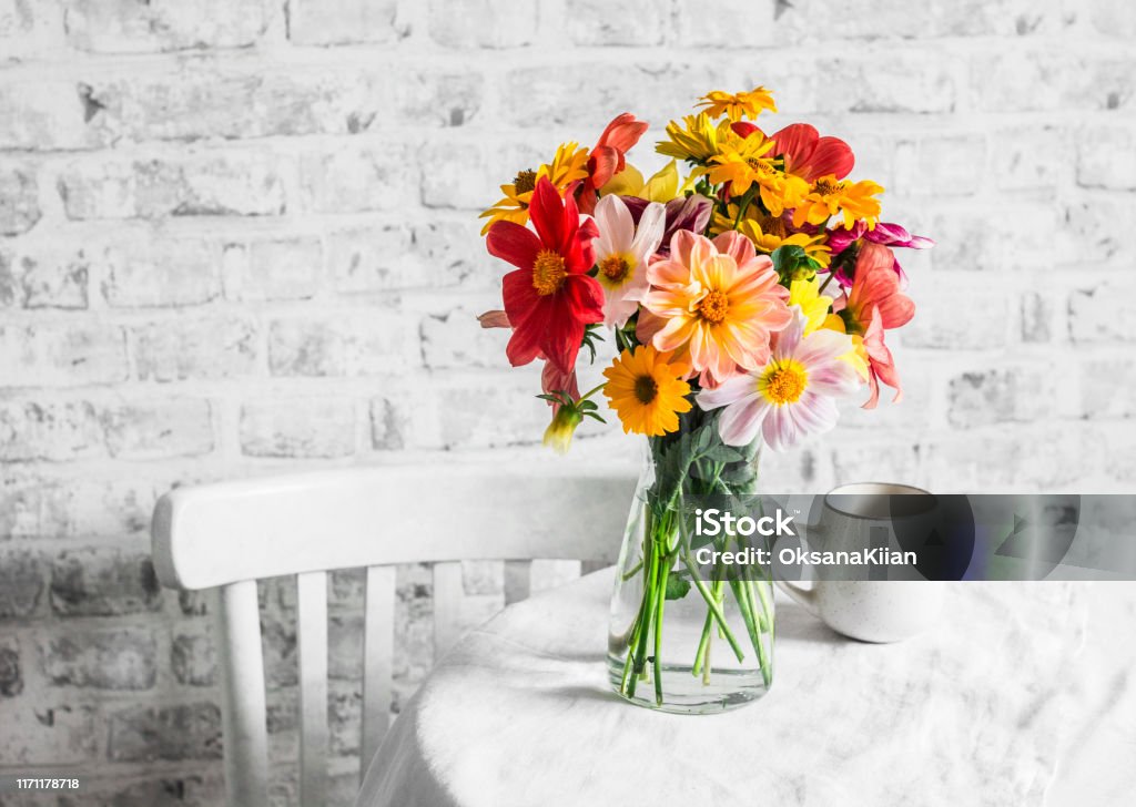 Bouquet of bright colorful autumn flowers on a bright table in a cozy light kitchen. Copy space, flat lay Flower Stock Photo
