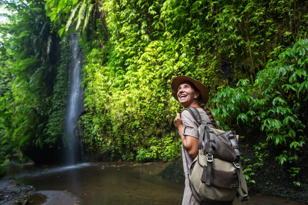 frau in der nähe von waterfal auf bali, indonesien - ökotourismus stock-fotos und bilder