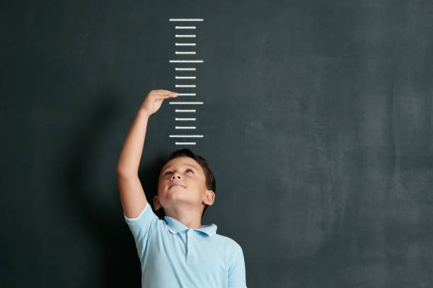 istock Child measuring his height on wall. He is growing up so fast. 1171180039