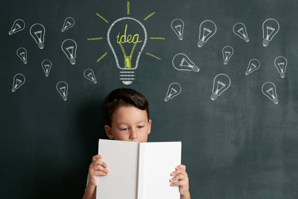 istock 6-7 years child is showing light bulb like idea on front of blackboard 1171181091