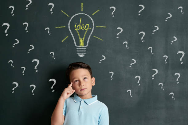 istock 6-7 years child is finding idea on front of blackboard 1171181324